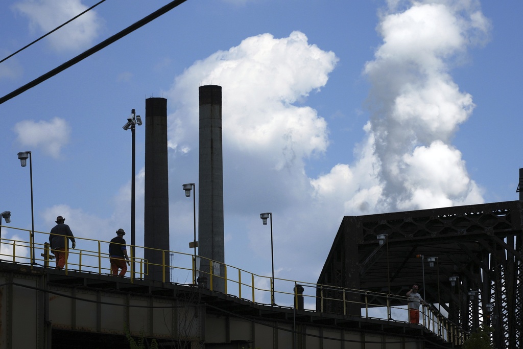 Steelworkers cross a bridge to the the Clairton Coke Works, a U.S. Steel plant, in Clairton, Pa., Tuesday, Aug. 12, 2025. (AP Photo/Gene J. Puskar)