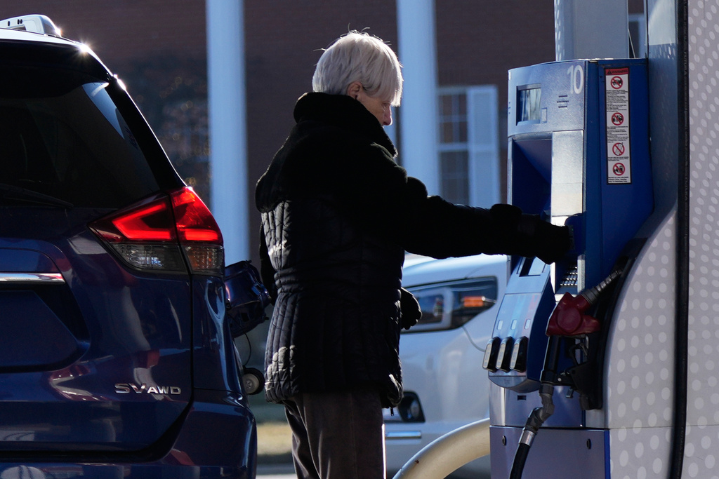 A woman checks gas prices before she fills up her vehicle's gas tank at a gas station in Buffalo Grove, Ill., Wednesday, Jan. 7, 2026. (AP Photo/Nam Y. Huh)