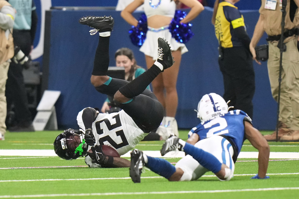Jacksonville Jaguars cornerback Jarrian Jones (22) tumbles after intercepting a pass intended for Indianapolis Colts wide receiver Josh Downs (2) during the second half of an NFL football game Sunday, Dec. 28, 2025, in Indianapolis. (AP Photo/AJ Mast)