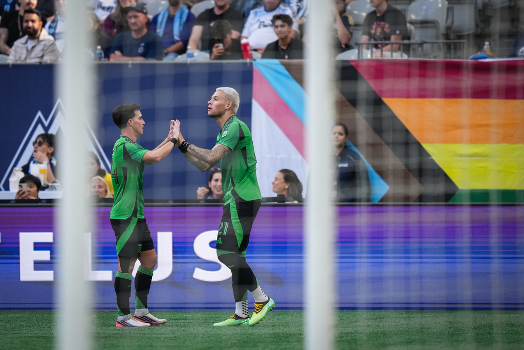 Austin FC's Christian Ramirez, right, celebrates after his goal with teammate Jorge Alastuey, left, during the first half of an MLS soccer match against the Vancouver Whitecaps in Vancouver, British Columbia, Sunday, Sept. 13, 2026. (Darryl Dyck/The Canadian Press via AP)
