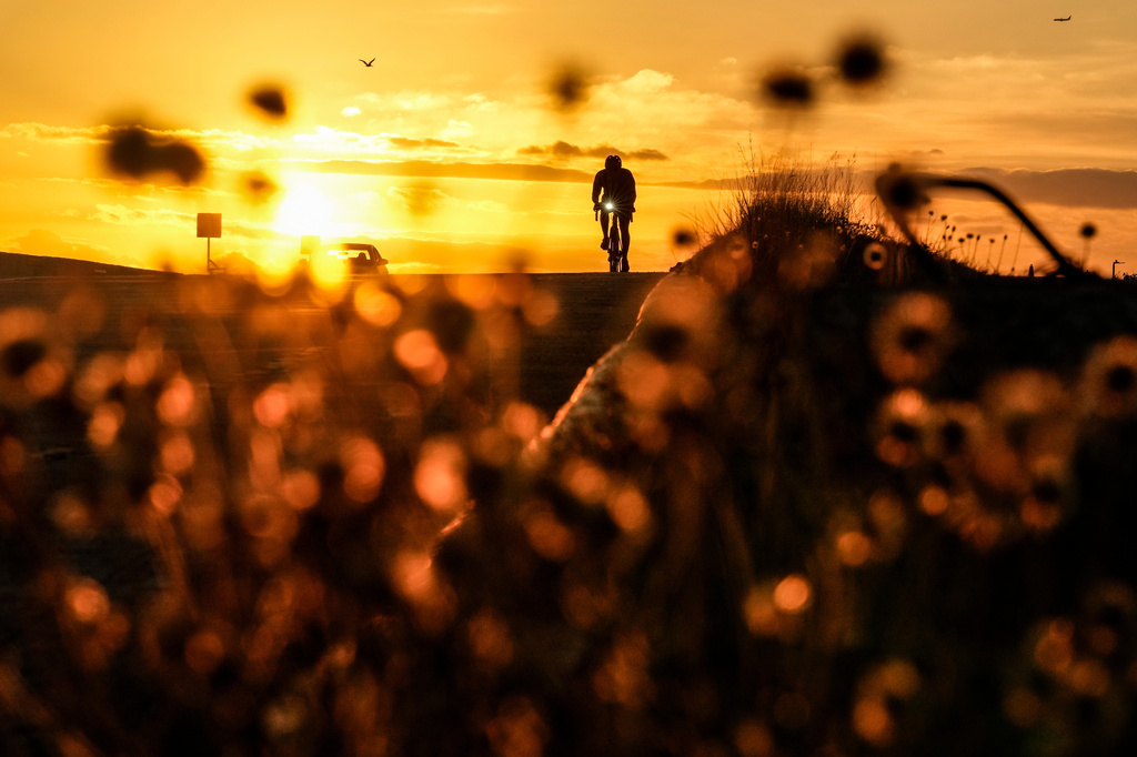 A cyclist rides on a coastal road at sunrise in Panama City, Wednesday, March 25, 2026. (AP Photo/Matias Delacroix)