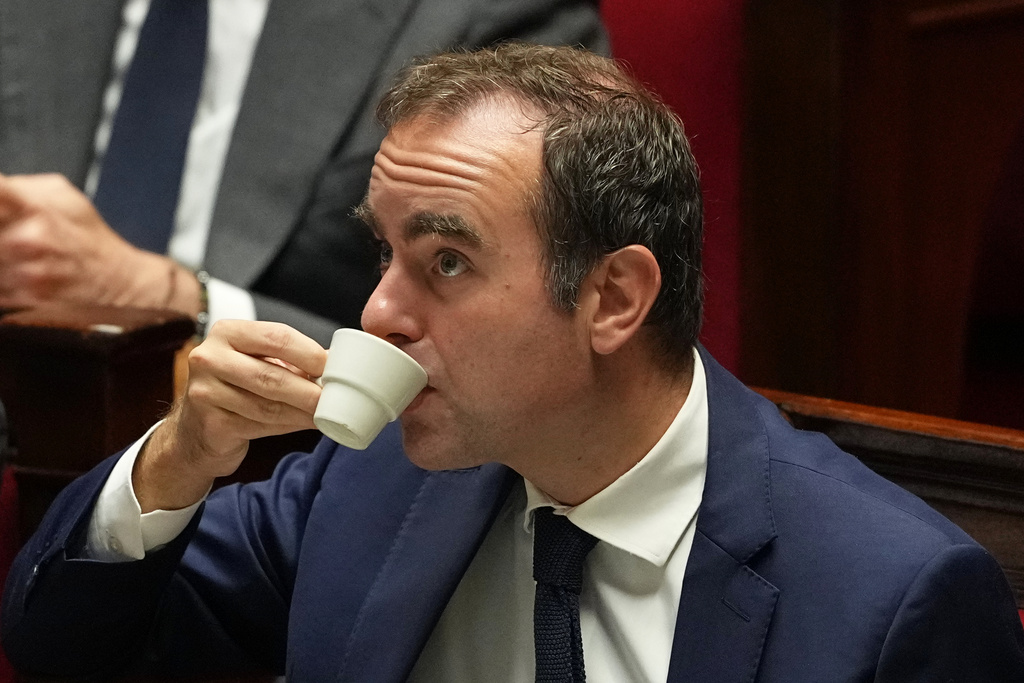 French Prime Minister Sebastien Lecornu drinks as he listens to speeches before a no-confidence vote, Thursday, Oct. 16, 2025 at the National Assembly in Paris. (AP Photo/Thibault Camus)