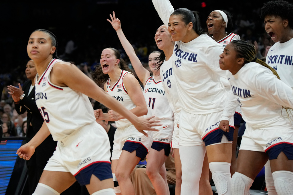 UConn players celebrate after UConn guard Azzi Fudd, left, made a 3-point shot against South Carolina during the second half of a woman's NCAA college basketball tournament semifinal game at the Final Four, Friday, April 3, 2026, in Phoenix. (AP Photo/Ross D. Franklin)