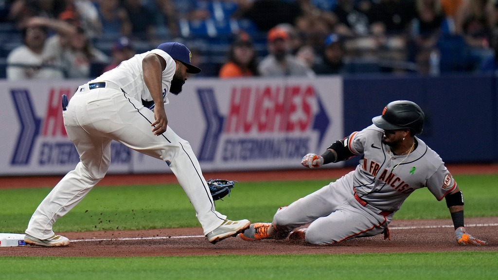 Tampa Bay Rays third baseman Junior Caminero (13) prepares to tag out San Francisco Giants' Luis Arraez at third base after Arraez tried to stretch a double into a triple during the fourth inning of a baseball game Friday, May 1, 2026, in St. Petersburg, Fla. (AP Photo/Chris O'Meara)