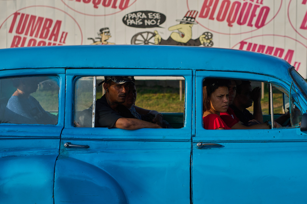 People ride in a shared taxi in front of a sign opposing the U.S. blockade on Cuba, in Havana, Tuesday, April 28, 2026. (AP Photo/Ramon Espinosa)