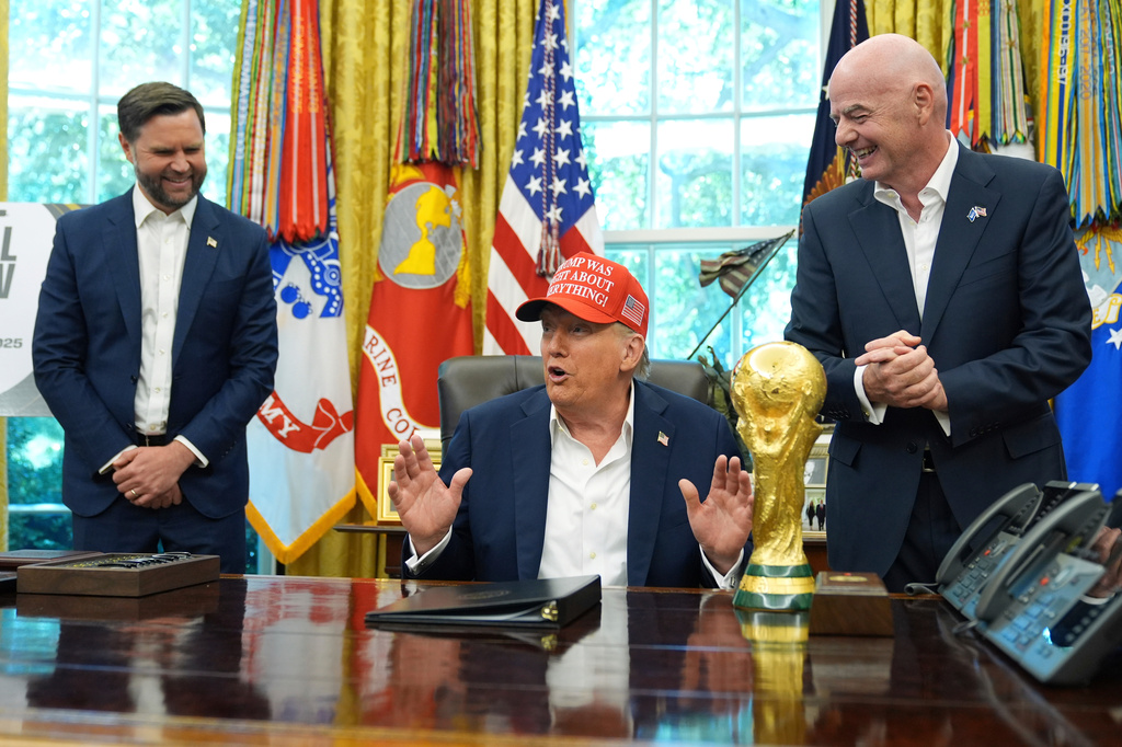 FILE - President Donald Trump speaks alongside the FIFA World Cup Winners Trophy as FIFA President Gianni Infantino, right, and Vice President JD Vance, left, watch in the Oval Office of the White House, Aug. 22, 2025, in Washington. (AP Photo/Jacquelyn Martin, File)