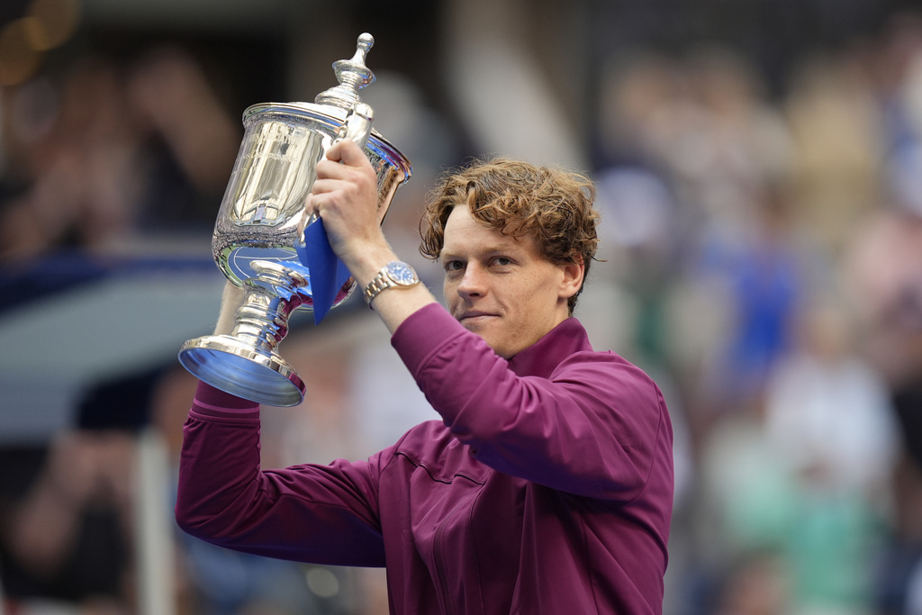 FILE - Jannik Sinner, of Italy, holds up the championship trophy after defeating Taylor Fritz, of the United States, in the men's singles final of the U.S. Open tennis championships, Sept. 8, 2024, in New York. (AP Photo/Seth Wenig, File)