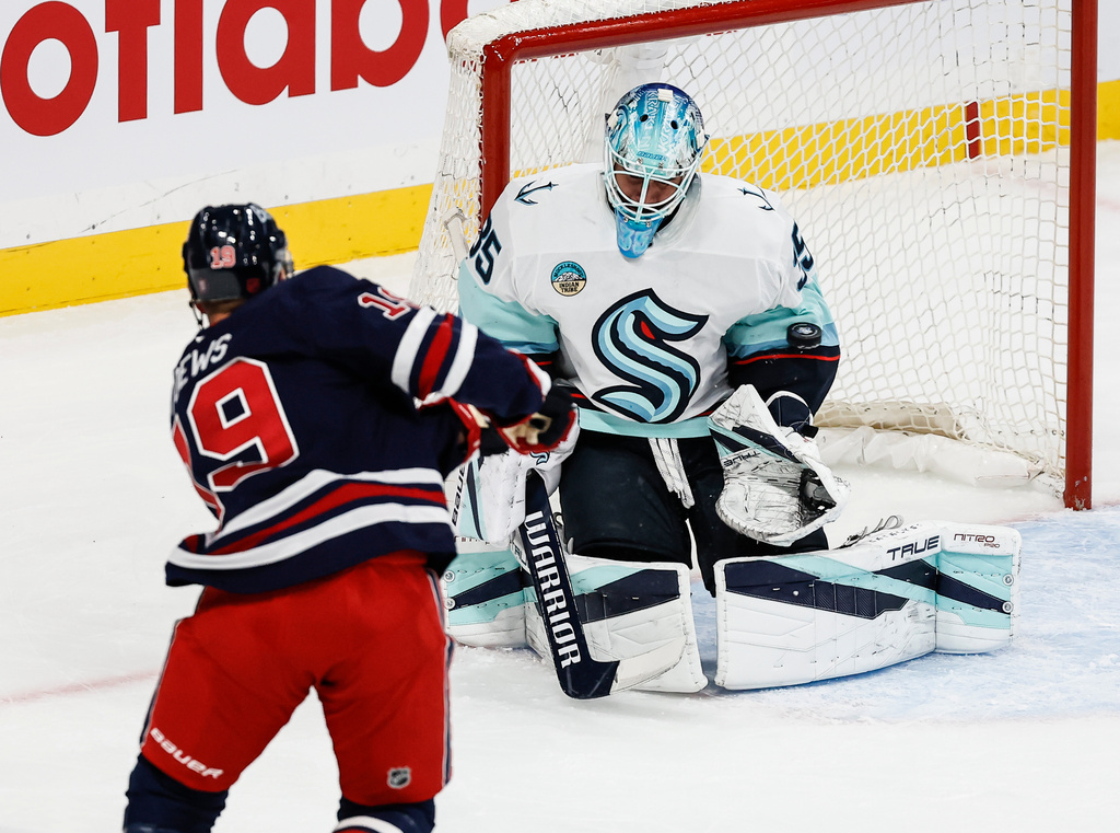 Seattle Kraken goaltender Joey Daccord (35) saves the shot from Winnipeg Jets' Jonathan Toews (19) during first period NHL action in Winnipeg on Thursday, Oct. 23, 2025. (John Woods/The Canadian Press via AP)