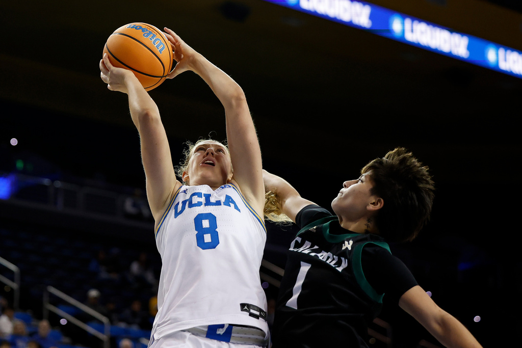 UCLA guard Gianna Kneepkens (8) drives to the basket with the ball while being guarded by Cal Poly guard Arissa Garcia (1) during the second half of an NCAA college basketball game Tuesday, Dec. 16, 2025, in Los Angeles. (AP Photo/Caroline Brehman)