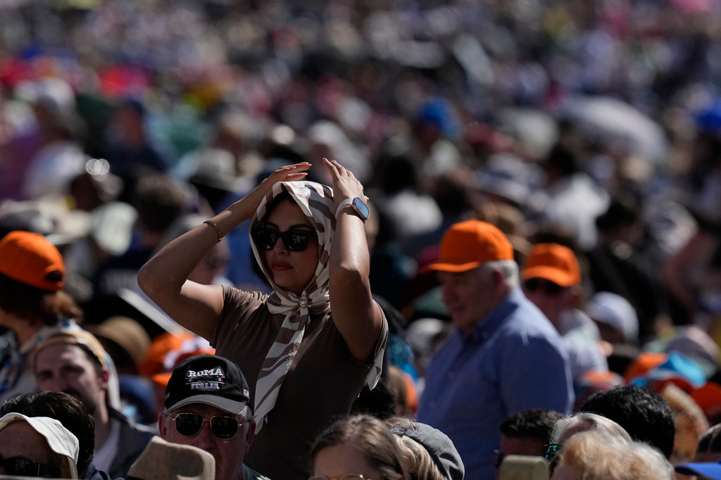 FILE - A faithful protects from the hot sun before Pope Leo XIV's weekly general audience in St. Peter's Square at The Vatican, May 27, 2026. (AP Photo/Alessandra Tarantino, File)
