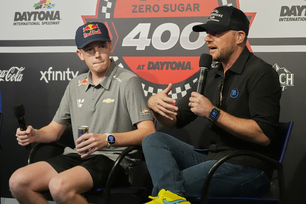 NASCAR driver Connor Zilisch, left, listens as Trackhouse Racing owner Justin Marks answers questions at an auto racing news conference at Daytona International Speedway, Saturday, Aug. 23, 2025, in Daytona Beach, Fla. (AP Photo/John Raoux)