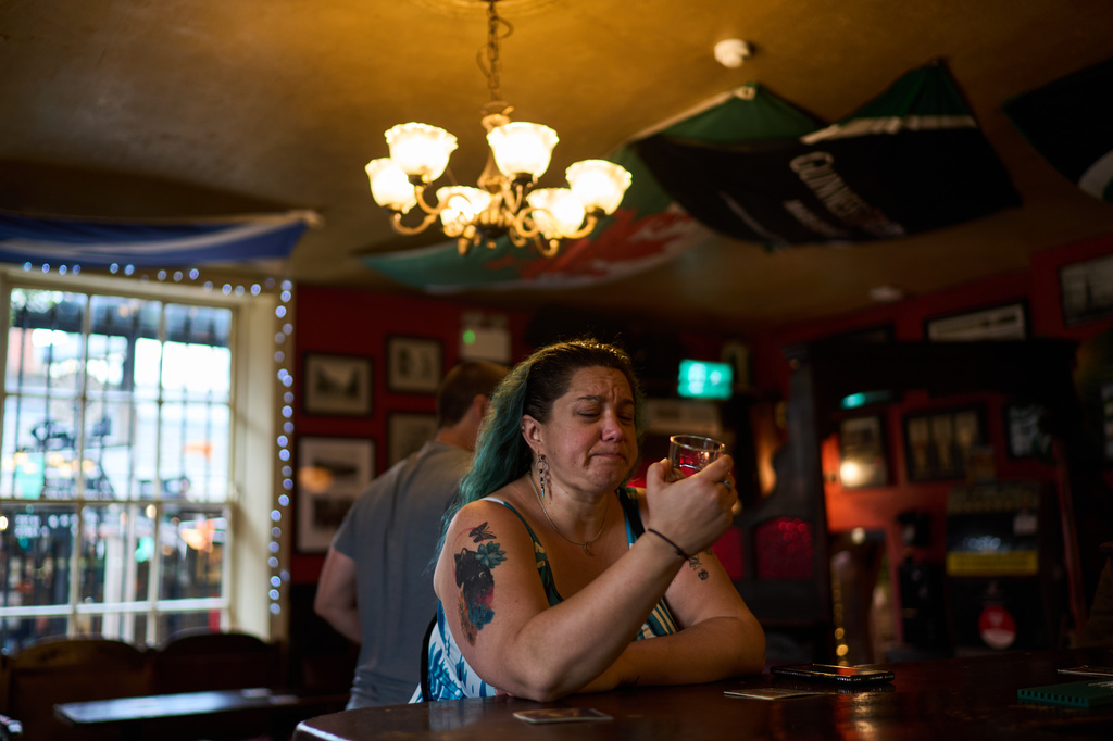 Jean Booth, who is traveling around Europe to get away after being targeted in a romance scam that lasted eight months, has her first taste of Irish whisky while visiting a pub, Oct. 1, 2025, in Dublin. (AP Photo/David Goldman)