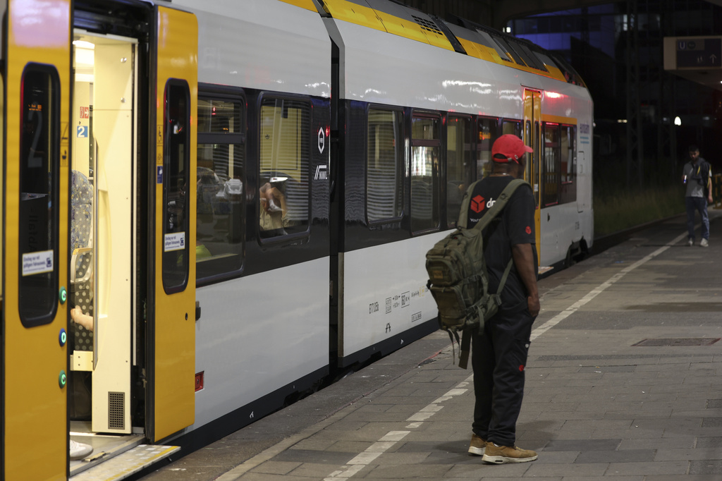 A passenger stands on a platform in front of a train at Duisburg Central Station, Tuesday, June 23, 2026. (Christoph Reichwein/dpa via AP)