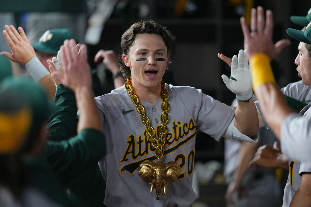 Athletics' Zack Gelof is greeted in the dugout after hitting a two-run home run off Texas Rangers pitcher Cal Quantrill during the ninth inning of a baseball game Friday, April 24, 2026, in Arlington, Texas. (AP Photo/Julio Cortez)