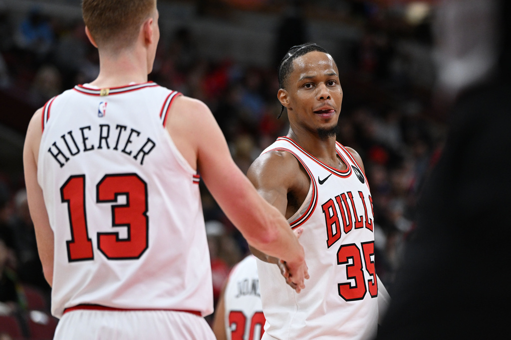 Chicago Bulls' Isaac Okoro (35) celebrates with teammate Kevin Huerter (13) during the final seconds of an NBA basketball game against the New Orleans Pelicans, Wednesday, Dec. 31, 2025, in Chicago. (AP Photo/Paul Beaty)