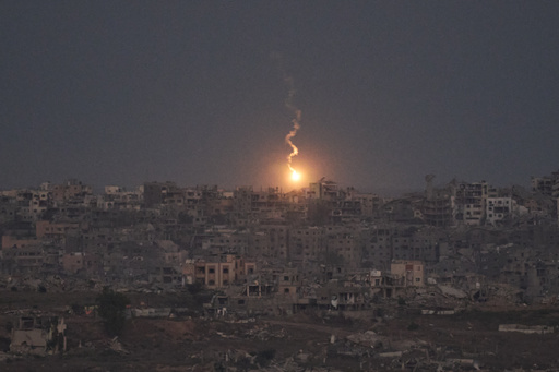 An Israeli army flare drifts over buildings destroyed during Israeli ground and air operations in the northern Gaza Strip, as seen from southern Israel, Monday, Oct. 6, 2025. (AP Photo/Leo Correa) An Israeli army flare drifts over buildings destroyed during Israeli ground and air operations in the northern Gaza Strip, as seen from southern Israel, Monday, Oct. 6, 2025. (AP Photo/Leo Correa)