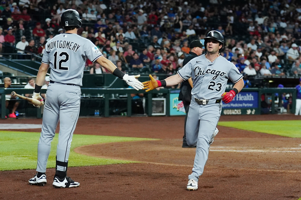 Chicago White Sox's Andrew Benintendi (23) celebrates his run scored against the Arizona Diamondbacks with White Sox's Colson Montgomery (12) during the third inning of a baseball game, Thursday, April 23, 2026, in Phoenix. (AP Photo/Ross D. Franklin)