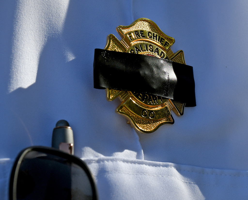 Charles Balke, of the Palisade Fire Department, wears a black band across his badge to honor three firefighters killed while fighting the Snyder Fire in Grand Junction, Colo. Sunday, June 28, 2026. (Gretel Daugherty via AP)