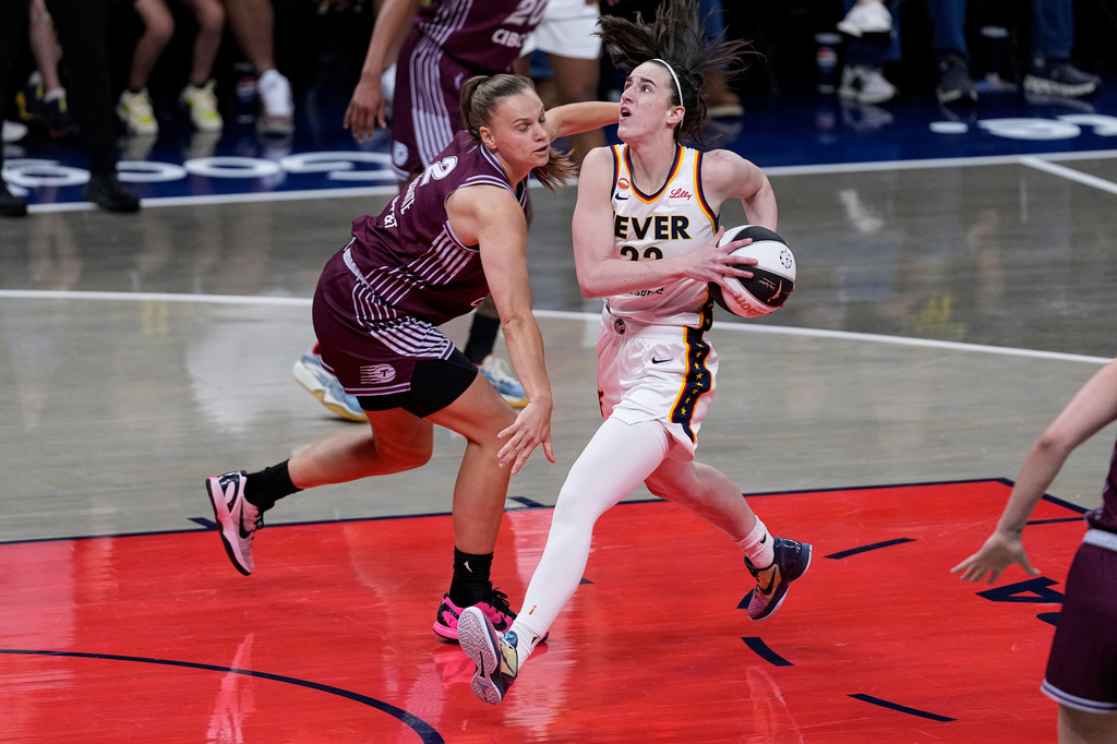 Indiana Fever guard Caitlin Clark, right, drives on Toronto Tempo forward Laura Juskaite in the first half of a WNBA Commissioner's Cup basketball game in Indianapolis, Tuesday, June 16, 2026. (AP Photo/Michael Conroy)