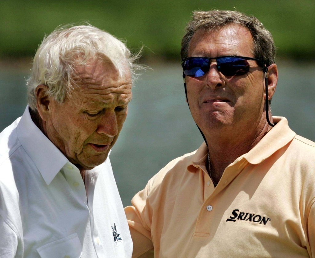 FILE - Golf Legend Arnold Palmer, left, ends his round with Fuzzy Zoeller, right, on the eighteenth green at the 66th Senior PGA Championship at Laurel Valley Golf Club in Ligonier, Pa., Friday, May 27, 2005. (AP Photo/Gene J. Puskar, File)