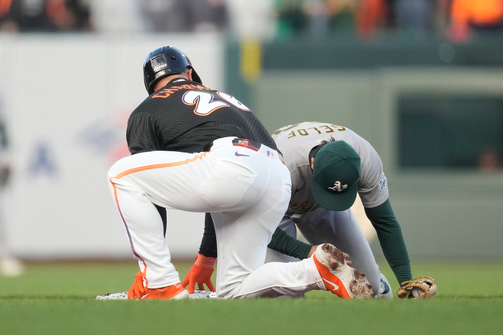 San Francisco Giants' Matt Chapman, left, looks toward Athletics second baseman Zack Gelof after Chapman hit an RBI double during the second inning of a baseball game Tuesday, June 23, 2026, in San Francisco. (AP Photo/Jeff Chiu)