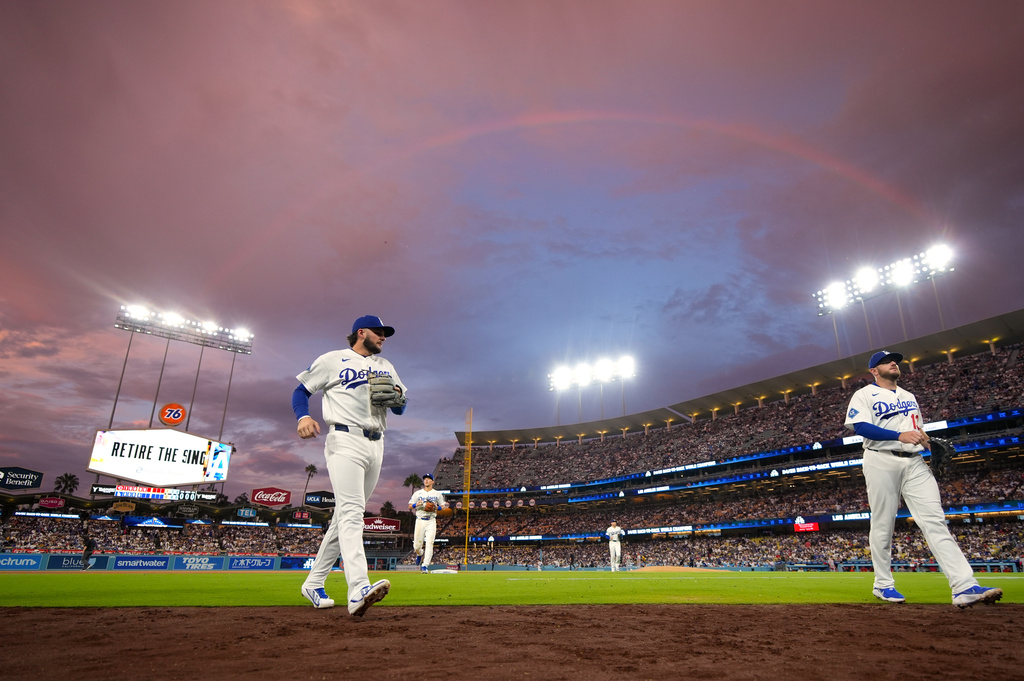 Los Angeles Dodgers' Alex Freeland, left, and Max Muncy walk in as a rainbow is seen above them after the top of the fifth inning of a baseball game against the Cincinnati Reds, Monday, Sept. 7, 2026, in Los Angeles. (AP Photo/Mark J. Terrill)