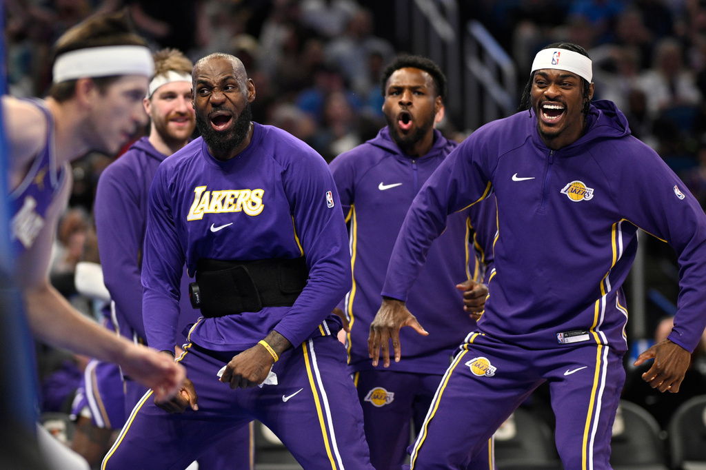 Los Angeles Lakers forward LeBron James, second from front right, and forward Jarred Vanderbilt, right, react after a dunk by guard Austin Reaves, left, during the first half of an NBA basketball game against the Orlando Magic, Saturday, March 21, 2026, in Orlando, Fla. (AP Photo/Phelan M. Ebenhack)