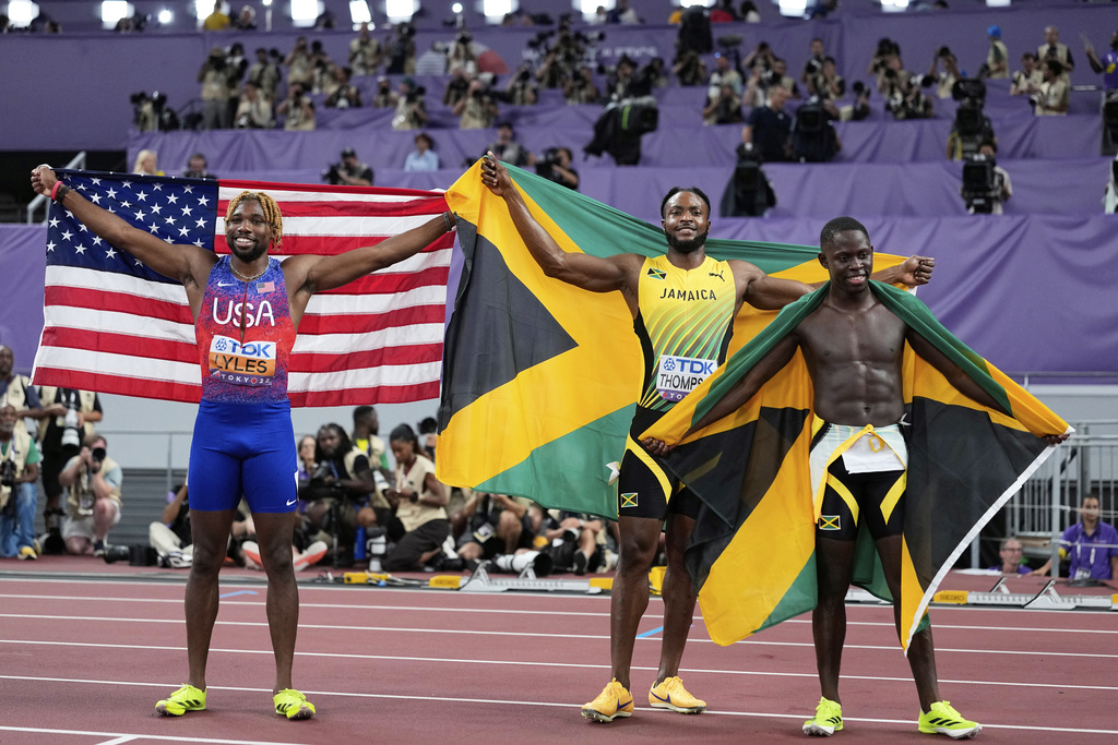 Jamaica's gold medalist Oblique Seville, right, and silver medalist Kishane Thompson, pose with bronze medalist United States' Noah Lyles, left, after competing in the men's 100 meters final at the World Athletics Championships in Tokyo, Sunday, Sept. 14, 2025. (AP Photo/Matthias Schrader)