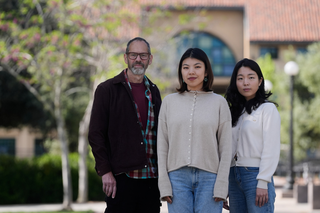 Dan Jurafsky, Stanford professor of computer science and linguistics, from left, Myra Cheng, Stanford Ph.D. candidate in computer science, and Cinoo Lee, Stanford postdoctoral fellow in psychology, pose for photos on the university campus in Stanford, Calif., Thursday, March 26, 2026. (AP Photo/Jeff Chiu)