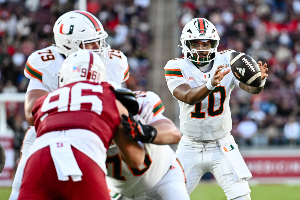 Miami quarterback Darian Mensah (10), right, receives a snap during the first half of an NCAA college football game against Stanford, Friday, Sept. 4, 2026, in Stanford, Calif. (AP Photo/Thien-An Troung)