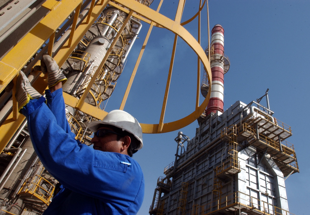 FILE - An oil technician climbs down a tower at a refinery in Jebel Ali, United Arab Emirates, about 30 kilometers (18 miles) south of Dubai, in March 2004. (AP Photo/Kamran Jebreili, File)