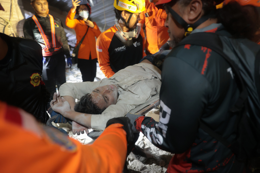 Rescuers pull out a survivor from a collapsed building at an Islamic boarding school in Sidoarjo, East Java, Indonesia, Monday, Sept. 29, 2025. (AP Photo/Trisnadi)