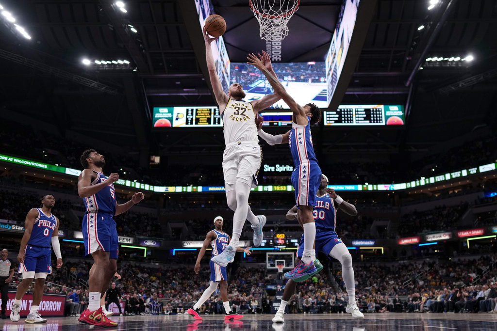 Indiana center Jay Huff, left, shoots over Philadelphia forward Dominick Barlow during the first half of an NBA basketball game in Indianapolis, Tuesday, Feb. 24, 2026. (AP Photo/AJ Mast)
