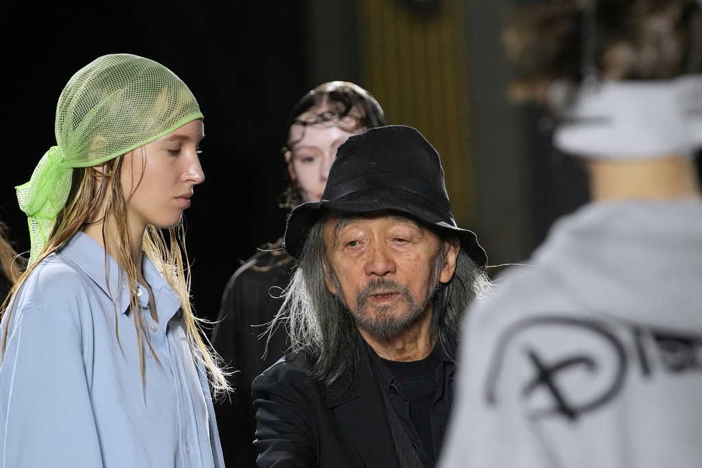 Designer Yohji Yamamoto speaks to models prior to the Yamamoto Spring/Summer 2026 collection presented in Paris, Friday, Oct. 3, 2025. (AP Photo/Christophe Ena)