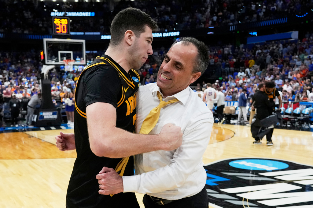 Iowa forward Alvaro Folgueiras, left, and head coach Ben McCollum celebrate after defeating Florida in the second half in the second round of the NCAA college basketball tournament, Sunday, March 22, 2026, in Tampa, Fla. (AP Photo/John Raoux)