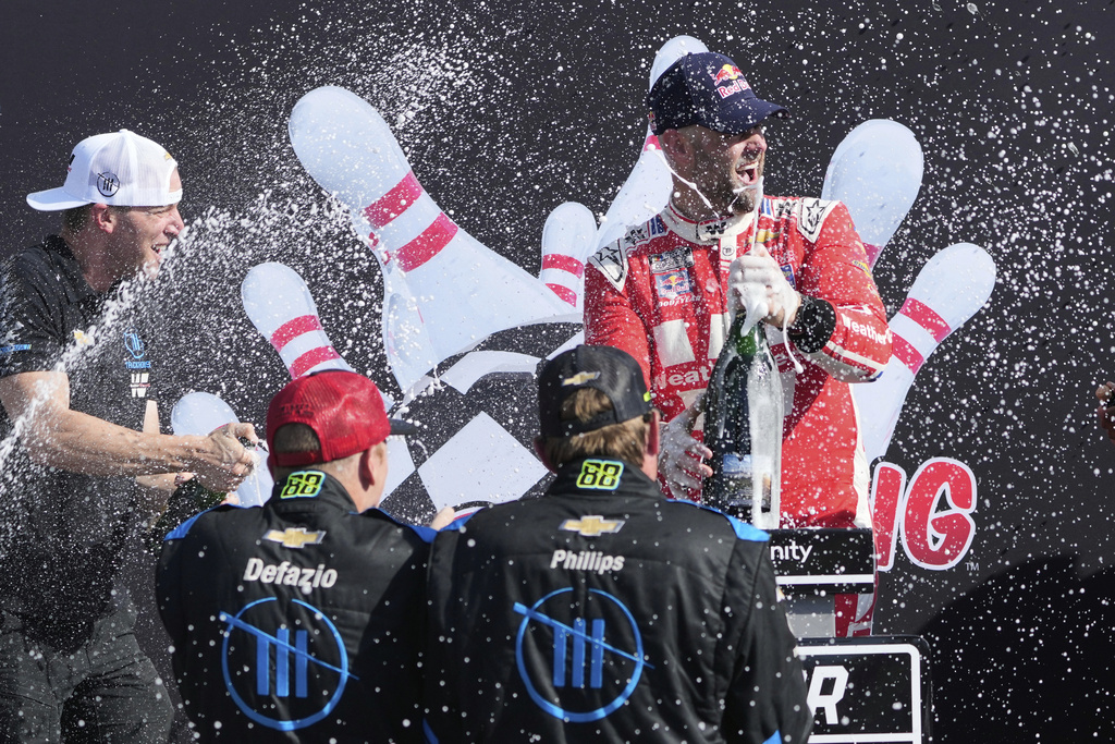Shane van Gisbergen, top, celebrates with his team in Victory Lane after finishing first during a NASCAR Cup Series auto race in Watkins Glen, N.Y., Sunday, Aug. 10, 2025. (AP Photo/Seth Wenig)