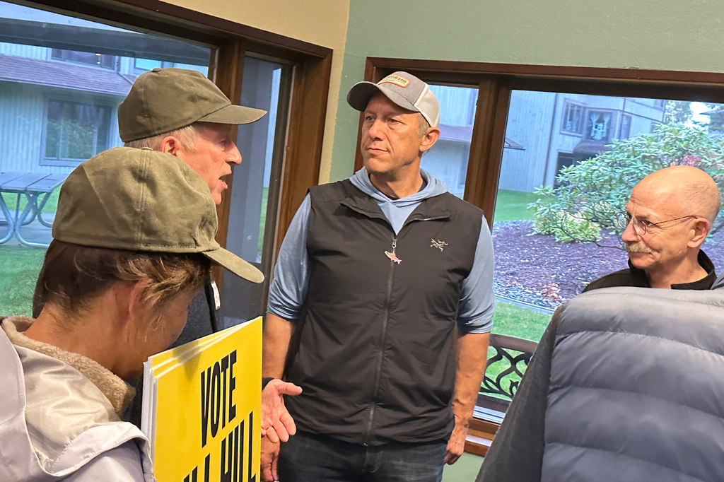 This photo made with a smartphone shows Independent Alaska U.S. House candidate Bill Hill, who is challenging Rep. Nick Begich, R-Alaska, speaking with supporters at a campaign event in Juneau, Alaska, Wednesday, Oct. 7, 2026. (AP Photo/Becky Bohrer)