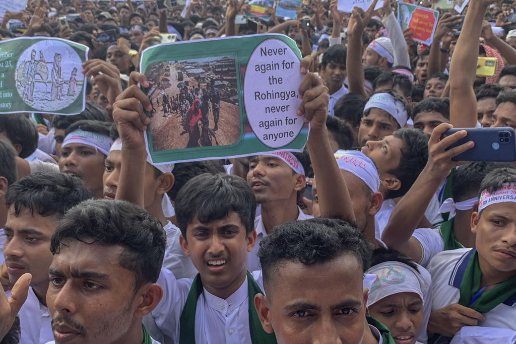 Rohingya refugees gather as they hold placards to demand safe return to Myanmar's Rakhine state as they mark the eighth anniversary of their mass exodus at their refugee camp at Kutupalong in Cox's Bazar district, Bangladesh, Monday, Aug. 25, 2025. (AP Photo/Shafiqur Rahman)