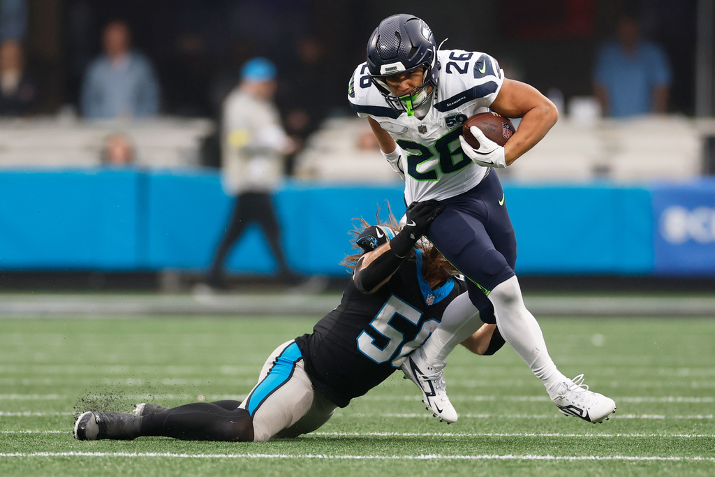 Seattle Seahawks running back Zach Charbonnet. is tackled by Carolina Panthers linebacker Christian Rozeboom during the second half of an NFL football game, Sunday, Dec. 28, 2025, in Charlotte, N.C. (AP Photo/Rusty Jones)