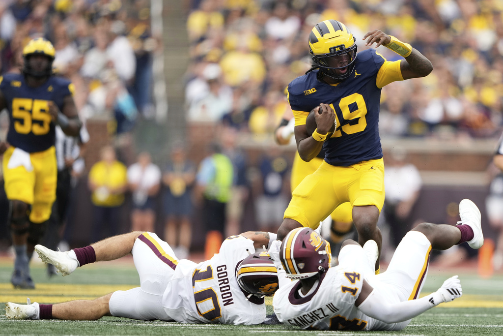 Michigan quarterback Bryce Underwood, top, runs past Central Michigan defensive back Elijah Gordon, bottom left, and linebacker Fernando Sanchez III during the first half of an NCAA college football game, Saturday, Sept. 13, 2025, in Ann Arbor, Mich. (AP Photo/Ryan Sun)