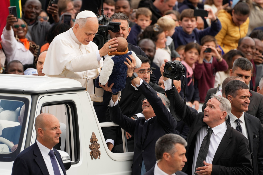 Vatican photographer Francesco Sforza, right, takes pictures of Pope Leo XIV arriving in St.Peter's Square on the occasion of the weekly general audience at the Vatican, Wednesday, Oct. 29, 2025. (AP Photo/Gregorio Borgia)