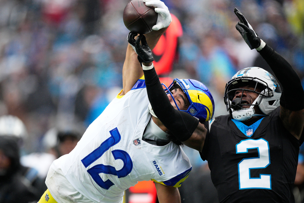 Los Angeles Rams wide receiver Puka Nacua catches a pass over Carolina Panthers cornerback Mike Jackson during the second half of an NFL football game, Sunday, Nov. 30, 2025, in Charlotte, N.C. (AP Photo/Jacob Kupferman)