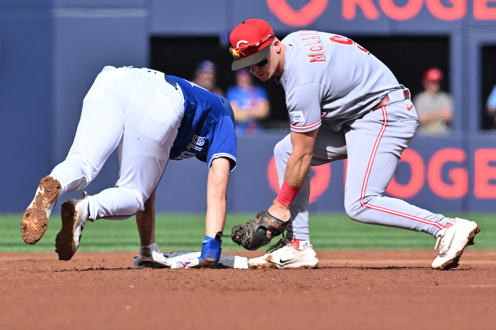 Toronto Blue Jays' Brett Bateman (21) dives safely into second base ahead of a tag by Cincinnati Reds second baseman Matt McLain (9) during the first inning of a baseball game in Toronto, Saturday, Sept. 26, 2026. (Jon Blacker/The Canadian Press via AP)