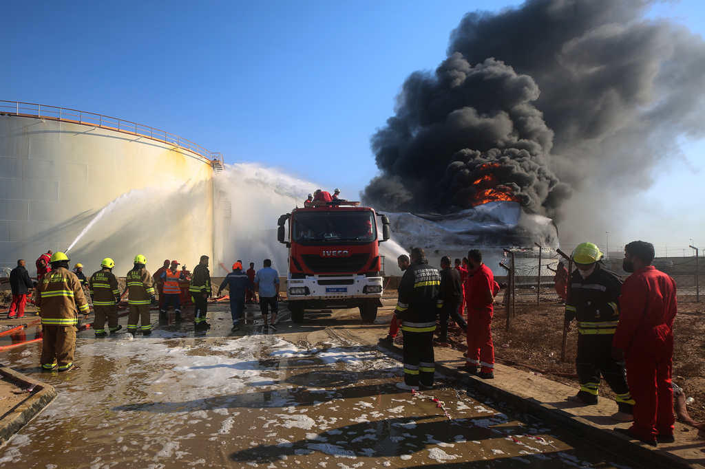 Firefighters work to contain a fire at the Zawiya oil refinery following a drone strike in Zawiya, Libya, Tuesday, Aug. 11, 2026. (AP Photo/Yousef Murad)
