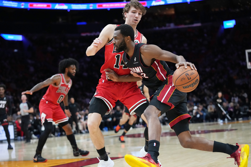 Miami Heat forward Andrew Wiggins, right, drives to the basket as Chicago Bulls forward Matas Buzelis (14) defends during the first half of an NBA basketball game, Sunday, Feb. 1, 2026, in Miami. (AP Photo/Lynne Sladky)