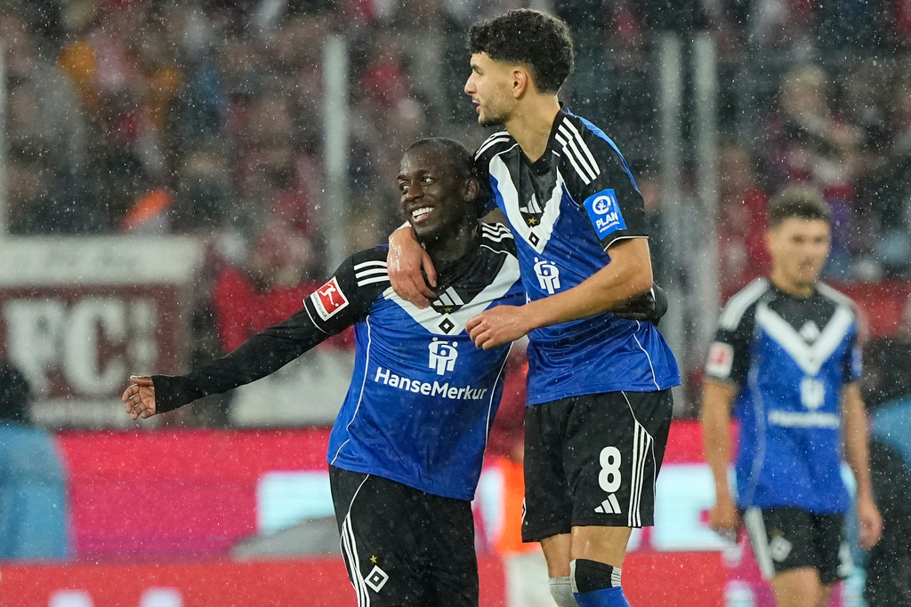 Hamburg's Jean-Luc Dompe, left, celebrates after scoring his side's opening goal during the German Bundesliga soccer match between Cologne and Hamburger SV, in Cologne, Germany, Sunday, Nov. 2, 2025. (AP Photo/Martin Meissner)