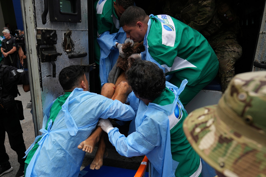 Getulio Vargas Hospital workers remove an injured person from a police truck after he was injured in a police operation against alleged drug traffickers in the Complexo do Alemao favela where the criminal organization "Comando Vermelho" operates in Rio de Janeiro, Tuesday, Oct. 28, 2025. (AP Photo/Silvia Izquierdo)