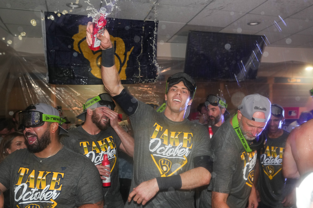 Milwaukee Brewers' Christian Yelich, center celebrates with teammates after the team defeated the San Diego Padres in Game 4 of baseball's National League Division Series Wednesday, Oct. 7, 2026, in San Diego, to advance to the National League Championship Series. (AP Photo/Gregory Bull)