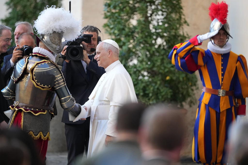 Pope Leo XIV is greeted by Pontifical Swiss Guard's 35th Commander Christoph Graf, left, upon his arrival to the swearing in ceremony of 27 Pontifical Swiss Guards cadets in the St. Damasus courtyard at the Vatican, Saturday, Oct. 4, 2025. (AP Photo/Andrew Medichini)