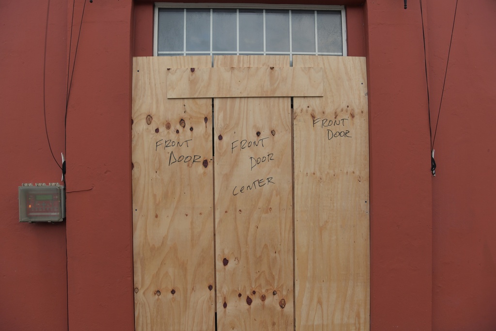 Wood covers up a door ahead of Hurricane Imelda's expected arrival in Hamilton, Bermuda, Wednesday, Oct. 1, 2025. (AP Photo/Anthony Wade)